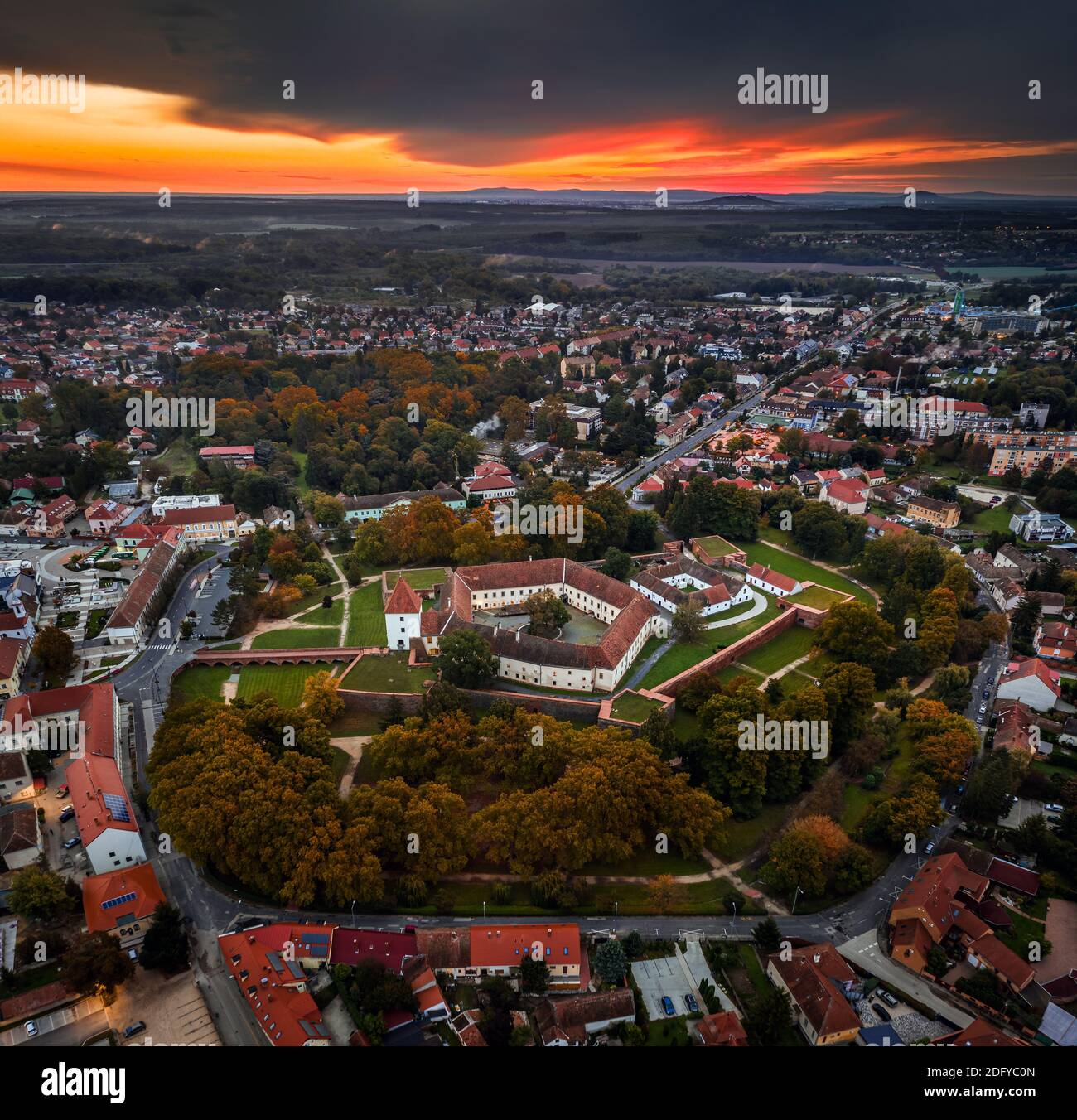 Sarvar, Hungary - Aerial panoramic view of the Castle of Sarvar (Nadasdy castle) from high above with a beautiful dramatic sunrise and rain clouds beh Stock Photo