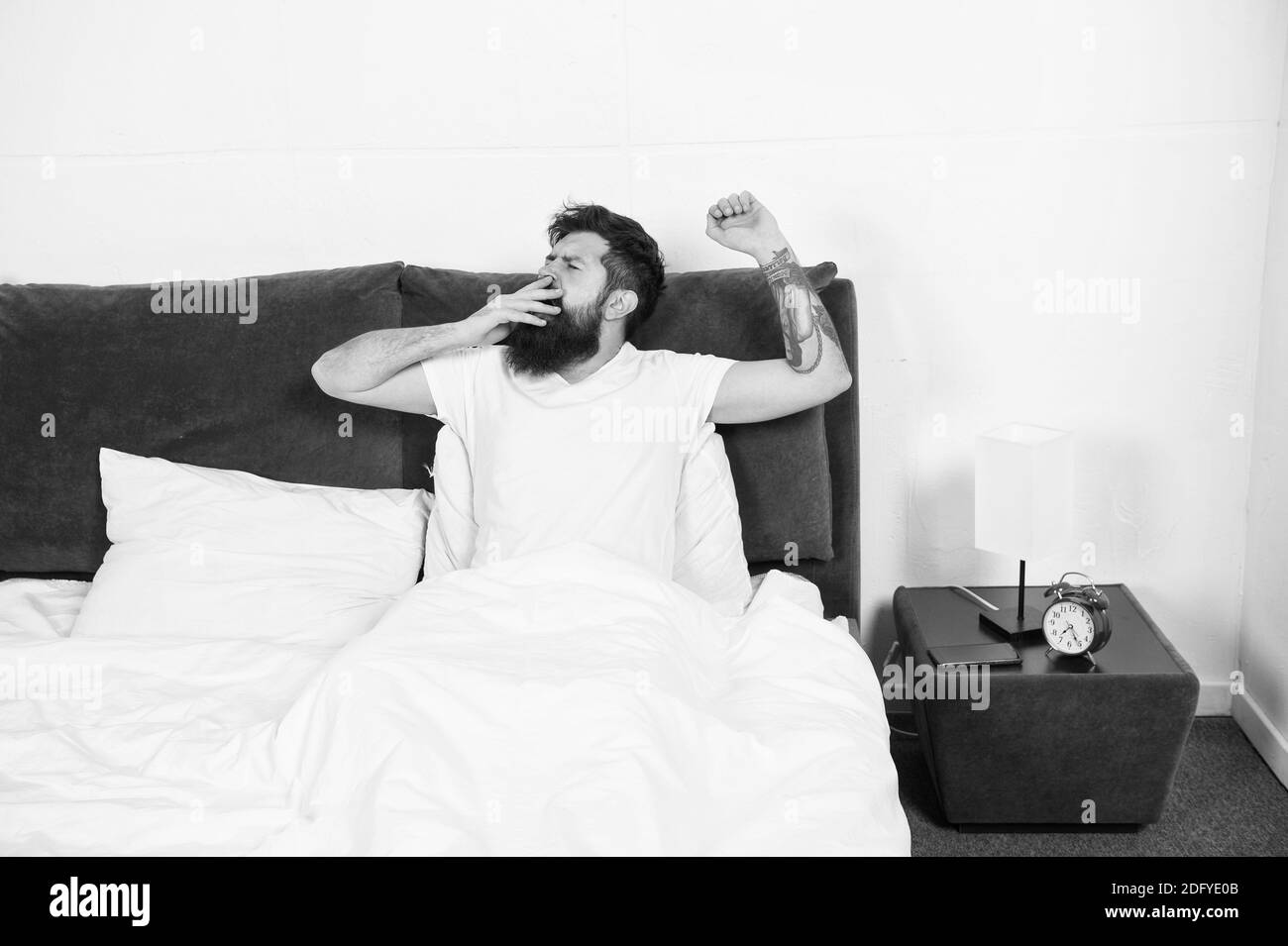 Bed is so comfortable in morning. Hipster give long yawns in bed. Bearded man stay in bed after wakeup. Bed time routine. Bedroom. Getting the rest your body needs. Stock Photo