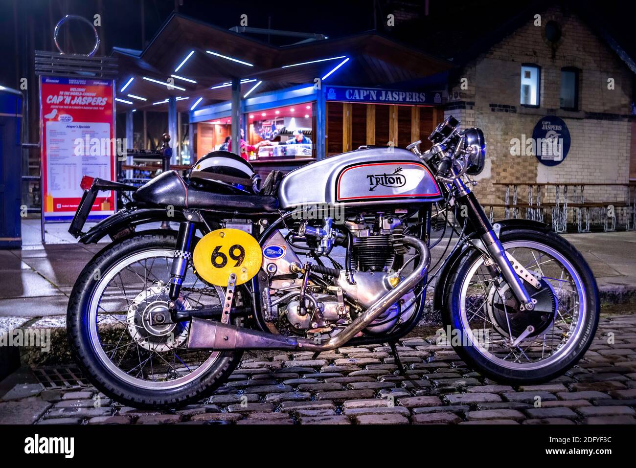 Triton motorbike by Cap'n Jaspers on The Barbican, Plymouth at night. Stock Photo