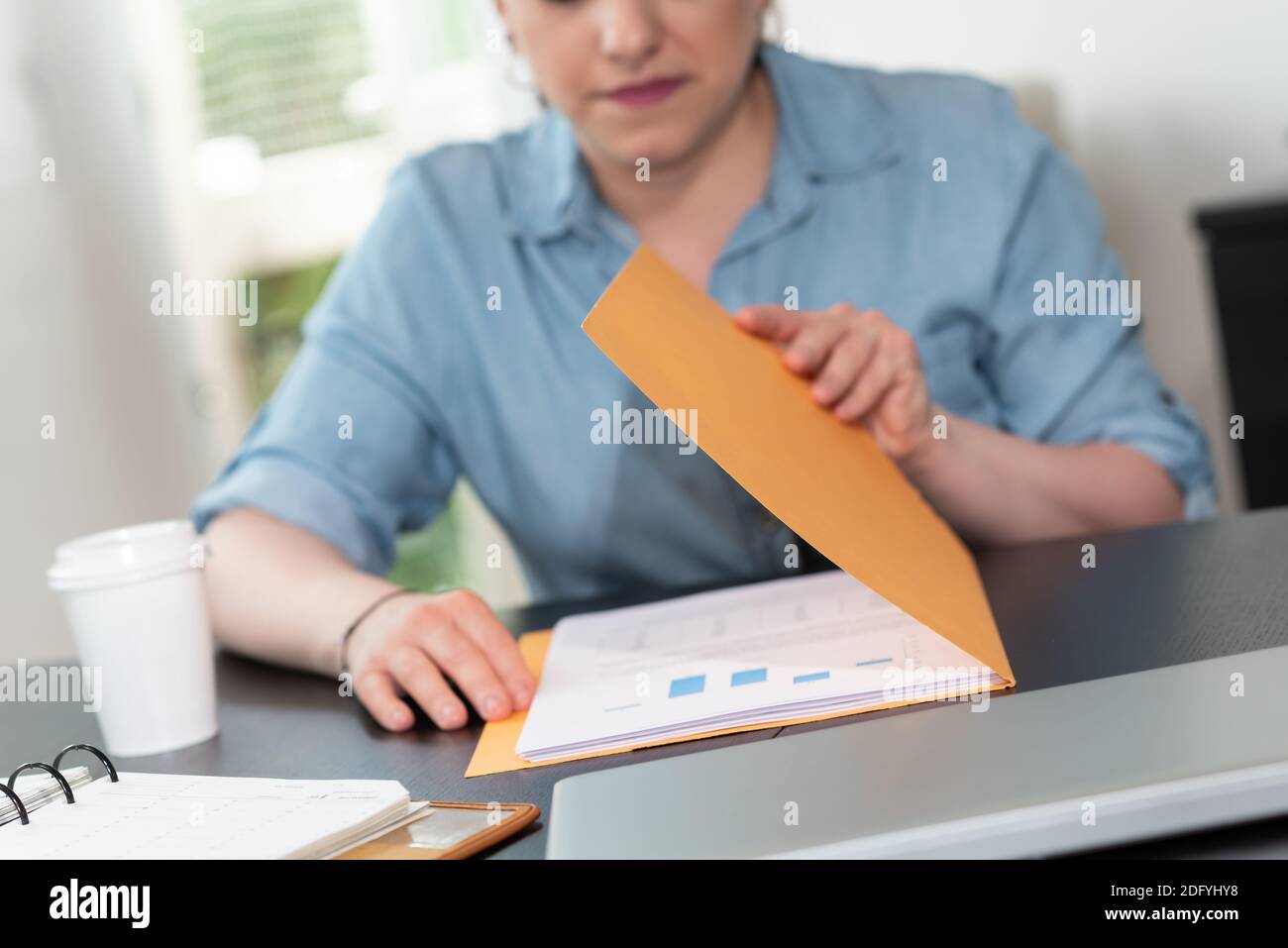 Businesswoman opening folder with paper documents Stock Photo - Alamy