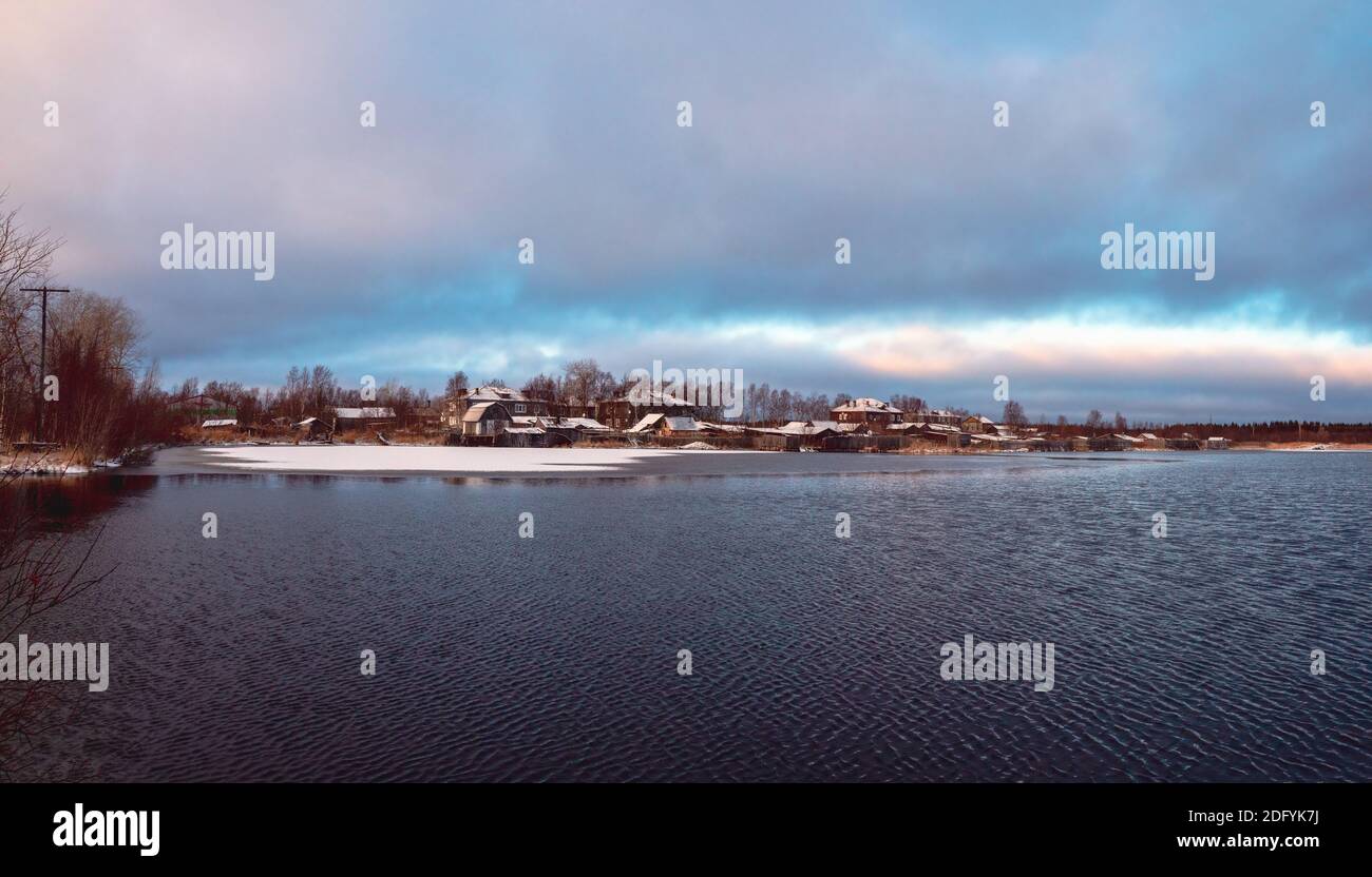 Panoramic winter view with old houses near a snow-covered lake. Authentic Northern city of Kem in winter. Russia. Stock Photo