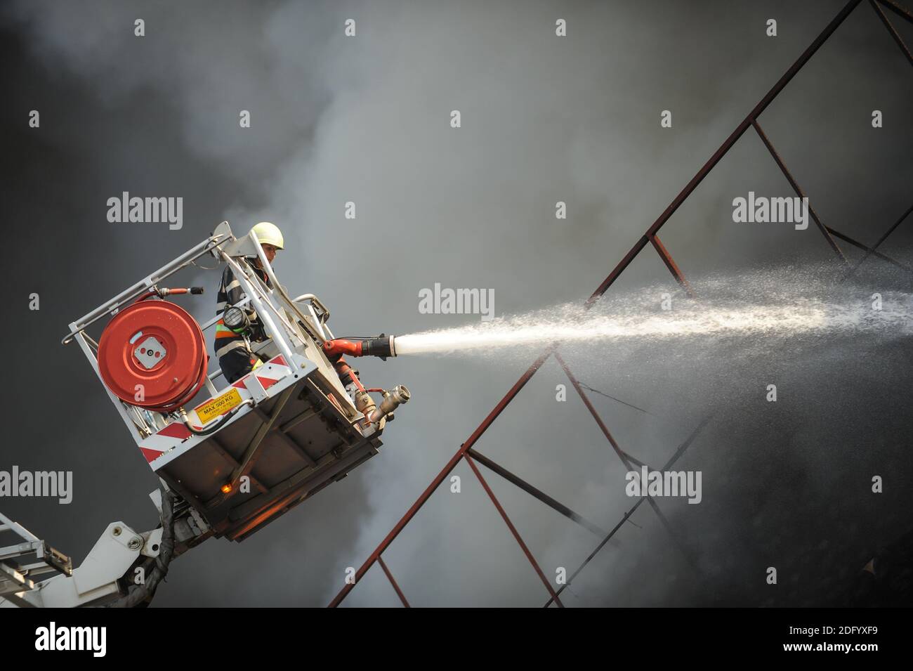 Bucharest, Romania - July 7, 2012: Firefighters try to extinguish the flames that engulfed a building. Stock Photo