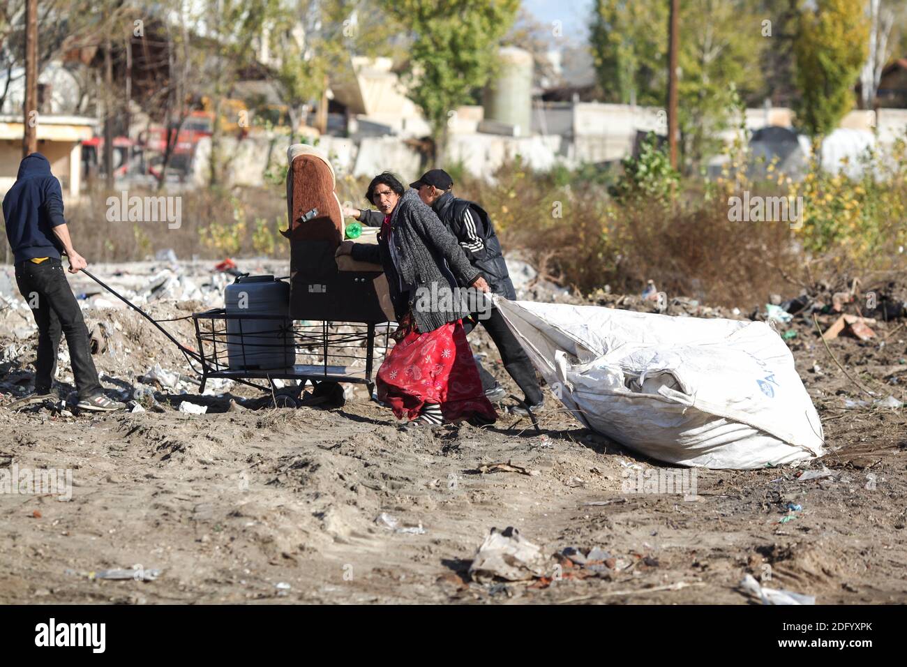 Bucharest, Romania - November 15, 2013: Poor people pack and carry their belongings after being evicted by the police from their makeshift shelters. Stock Photo