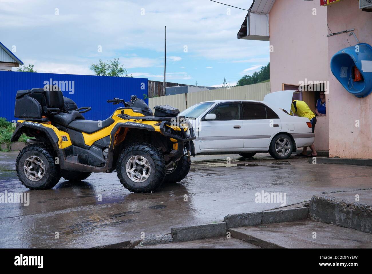 The quad bike and the car stopped near a store in the village of Parnaya, Sharipovsky district. Krasnoyarsk Territory, Russia Stock Photo