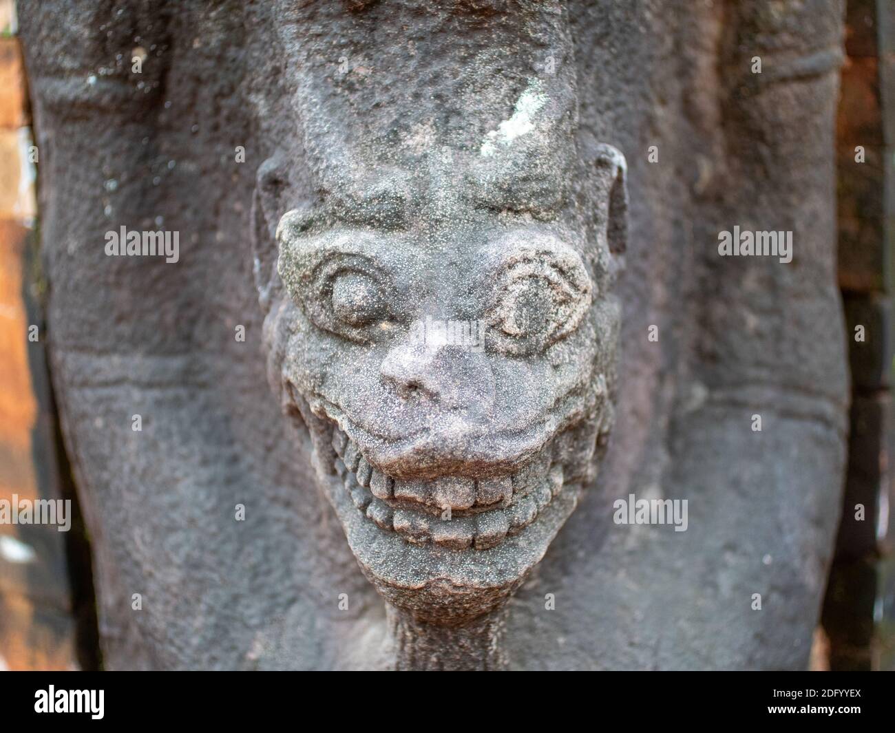 A stone statue of a demon-like deity on the wall of a temple at Preah Ko Temple, Angkor Wat, Cambodia Stock Photo