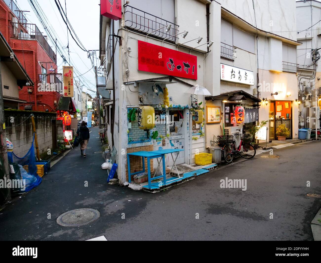 A solo man walks down an alleyway past restaurants and Izakaya in Itabashi City, Tokyo. Stock Photo