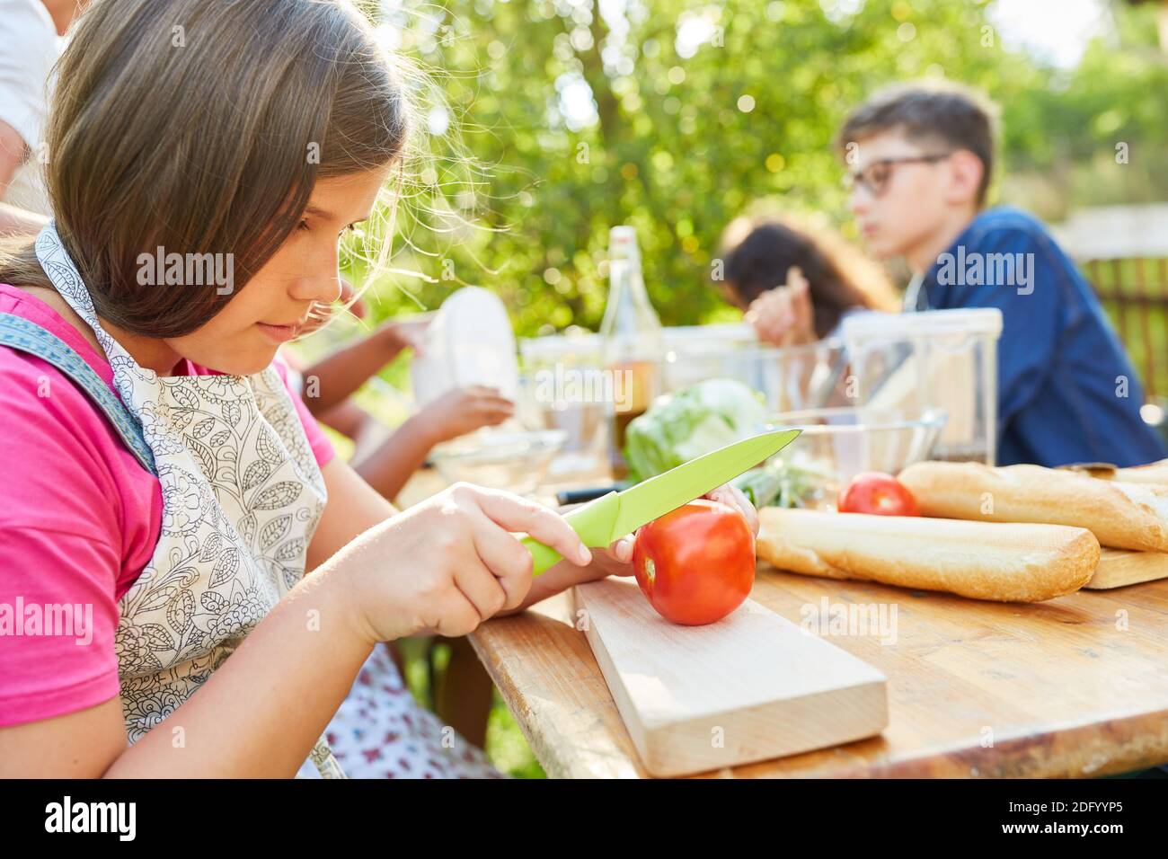 Children prepare salad in the summer camp cooking class and learn about healthy eating Stock Photo