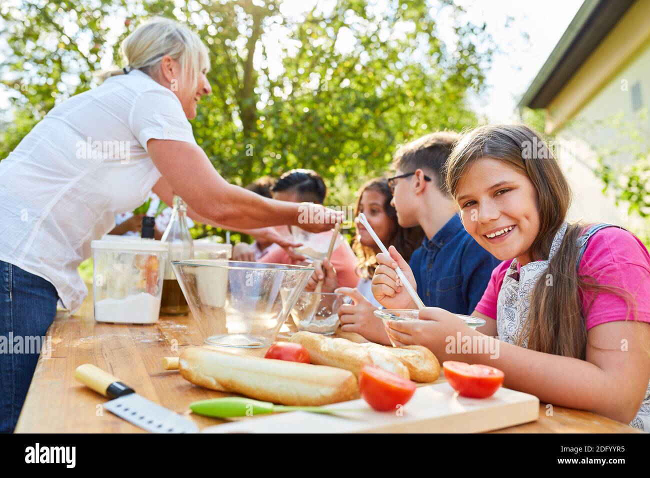 Teacher and children together in summer camp cooking class for healthy eating Stock Photo