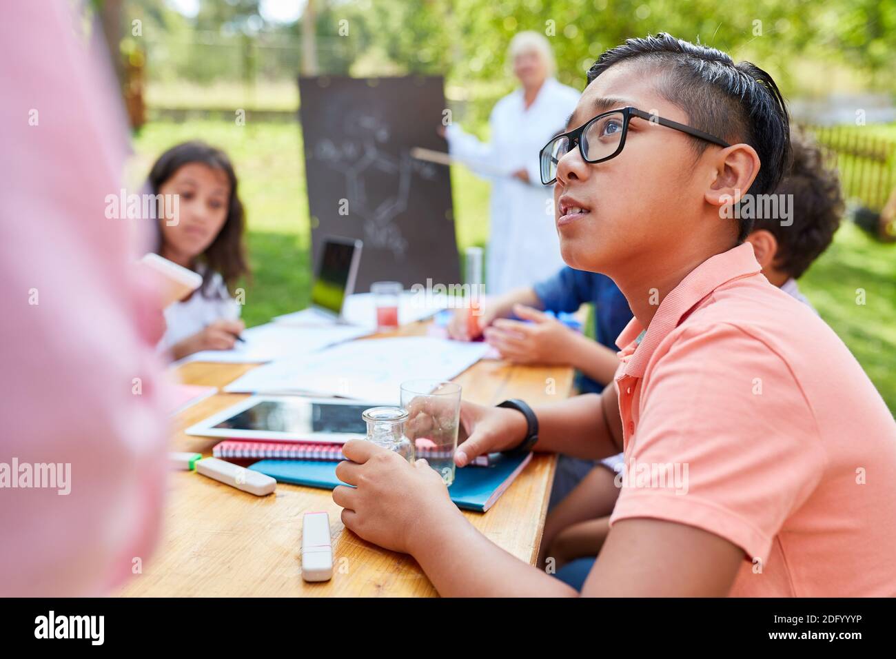 Tutoring teacher helps children with arithmetic in the summer school vacation course Stock Photo