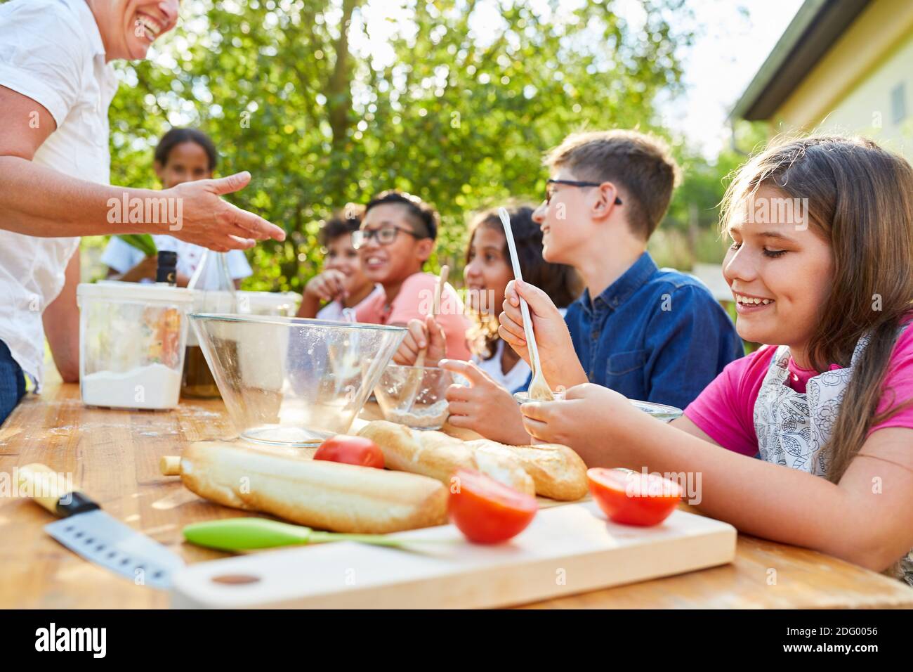 Group of children has fun learning to cook healthy in the summer camp cooking class Stock Photo