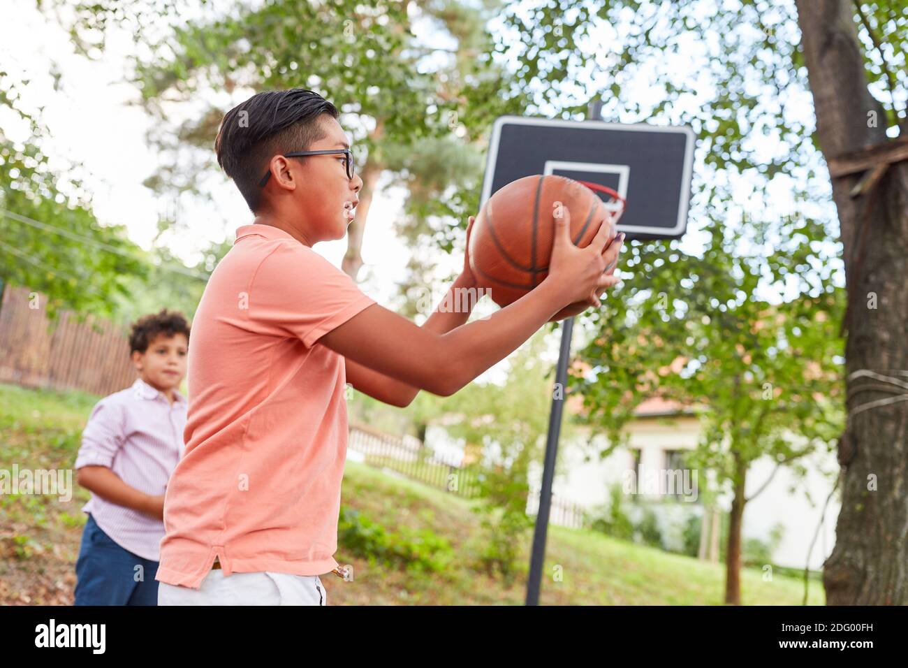 Children at the basketball tournament in summer camp or during training in front of the net Stock Photo