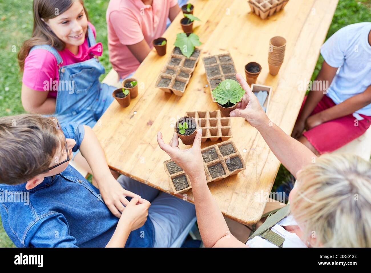 Teacher and children gardening and planting in the ecological holiday camp Stock Photo