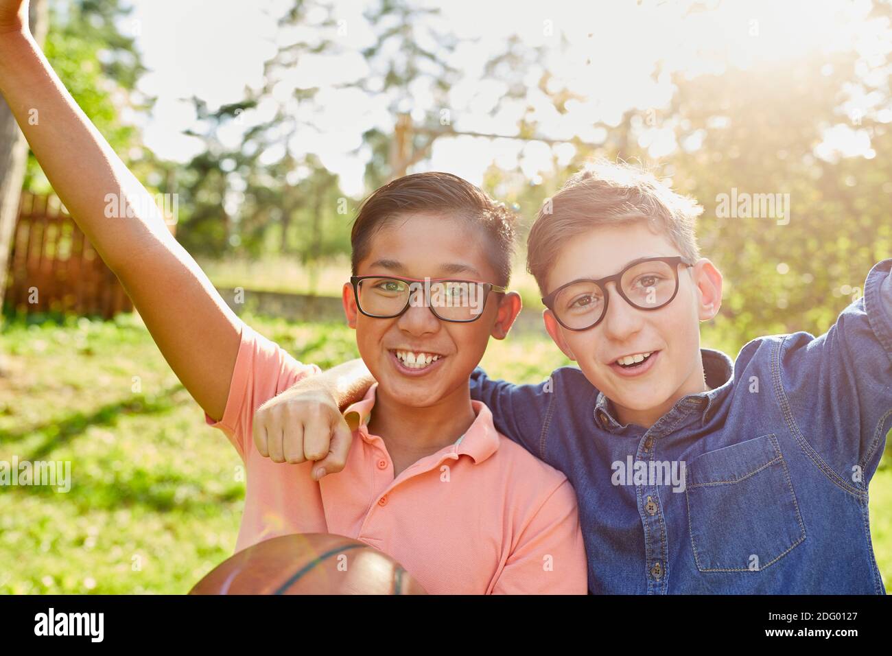 Two cheering children with basketball in the park at summer camp on vacation Stock Photo