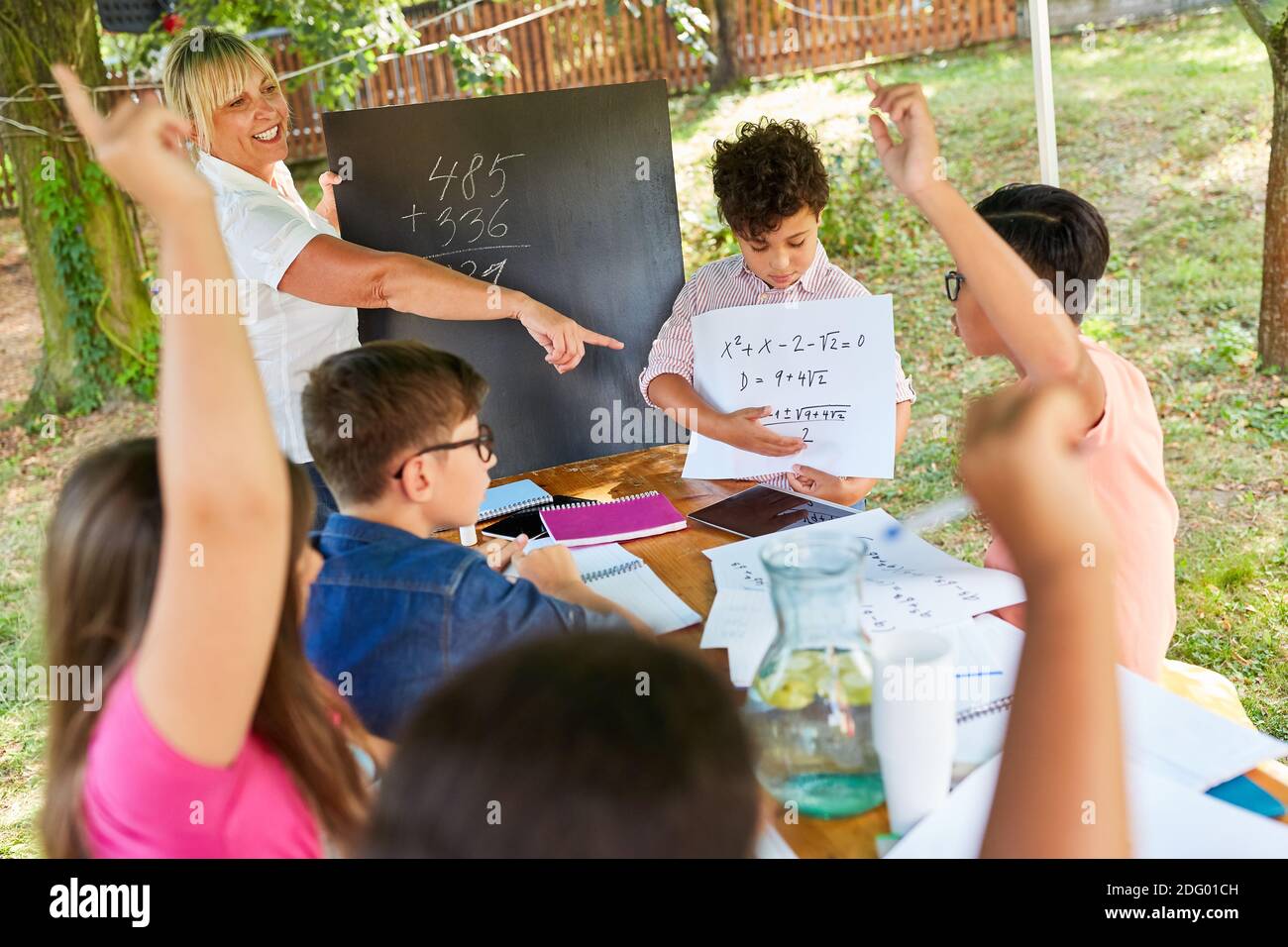 Teacher gives tutoring lessons in math for children in the summer school vacation course Stock Photo