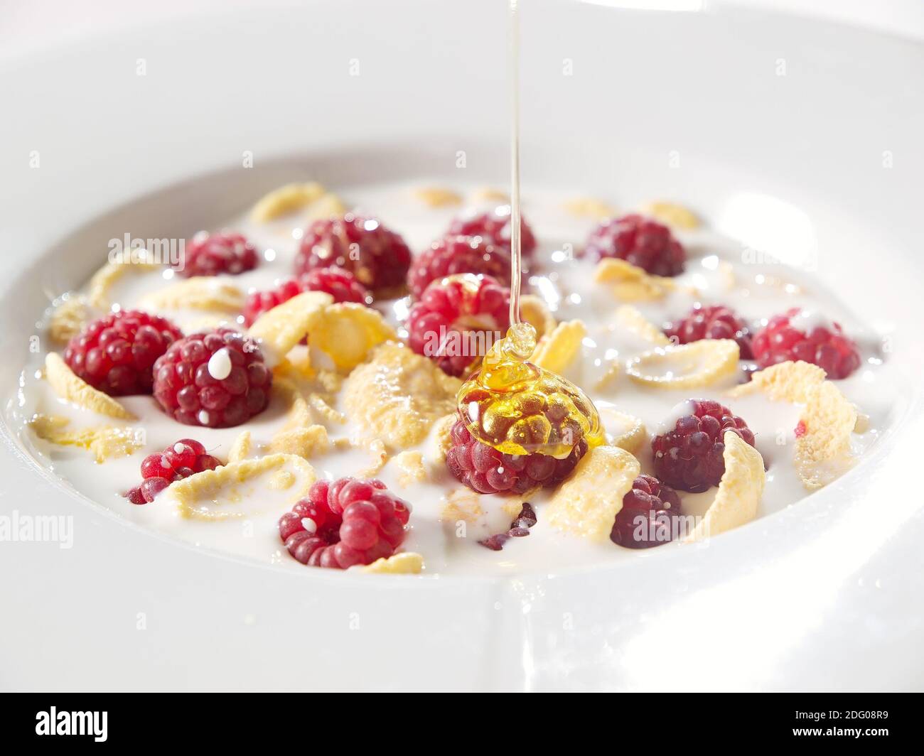 https://c8.alamy.com/comp/2DG08R9/honey-corn-flakes-with-fresh-raspberry-and-pouring-milk-in-bowl-2DG08R9.jpg