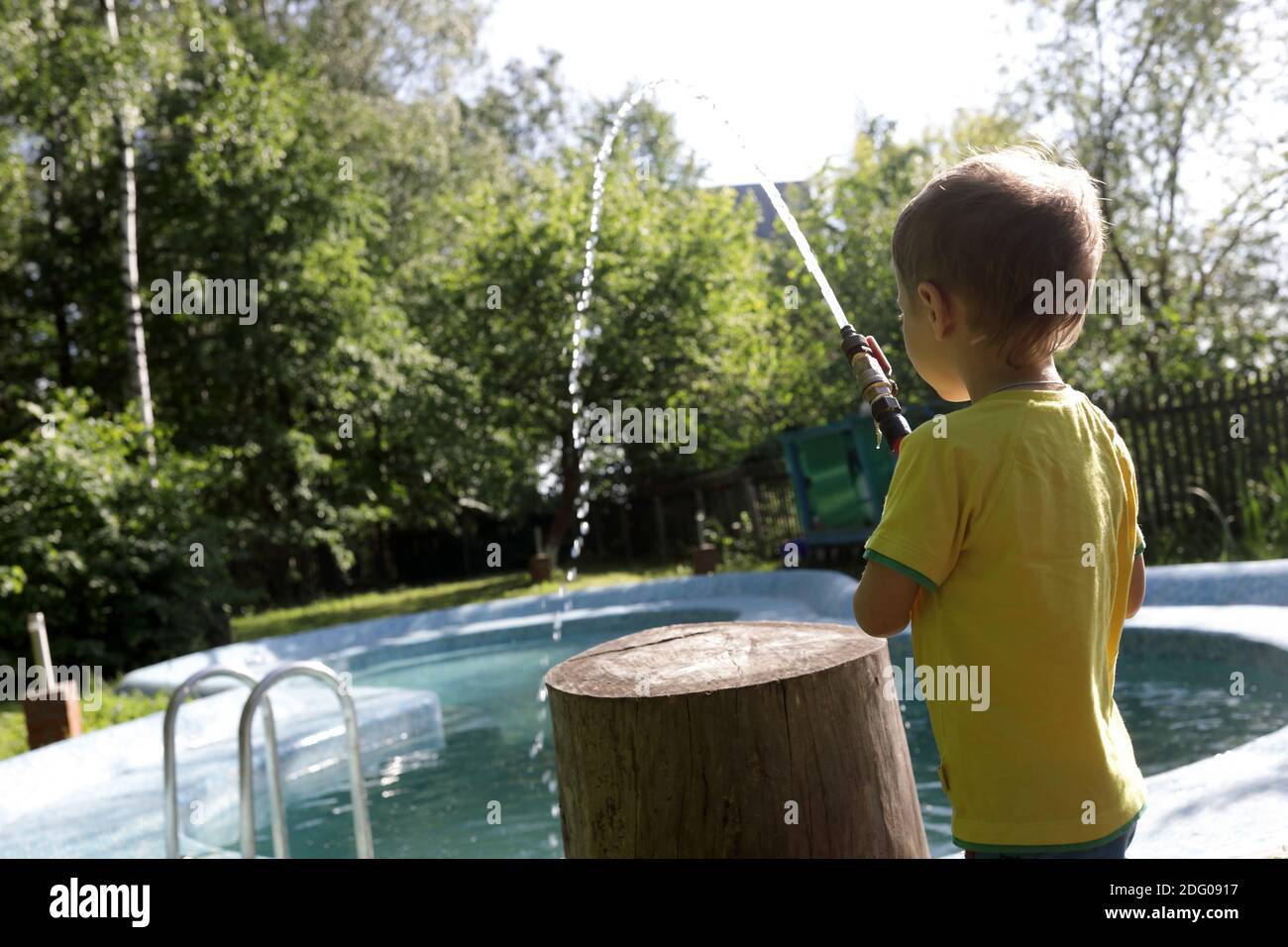 boy-filling-pool-with-water-at-backyard-stock-photo-alamy