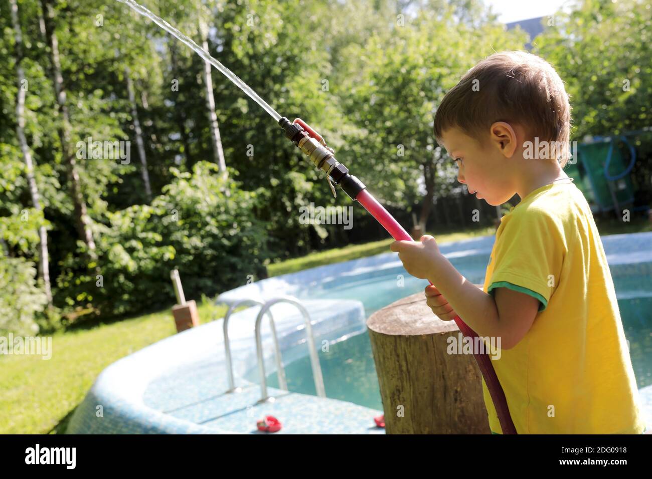 Child filling pool with water at backyard Stock Photo Alamy