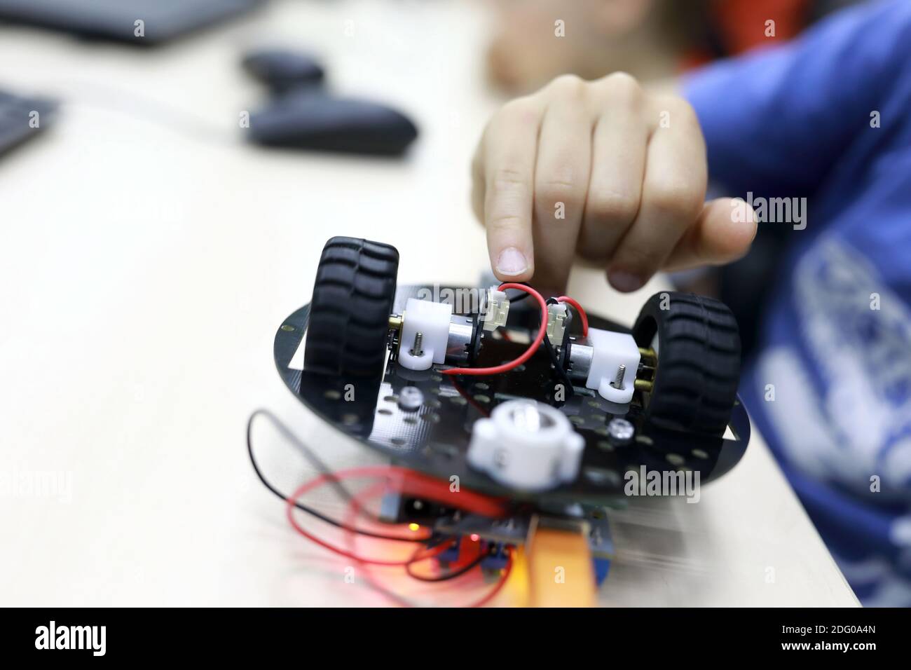 Person programming robot at table in workshop Stock Photo - Alamy
