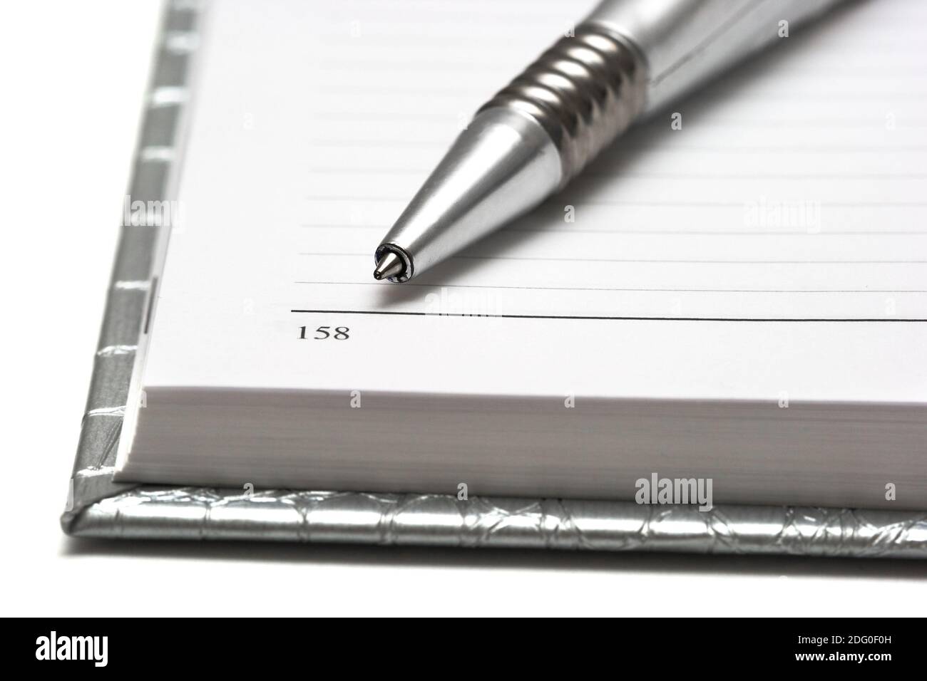 Silver pen with opened notebook Stock Photo