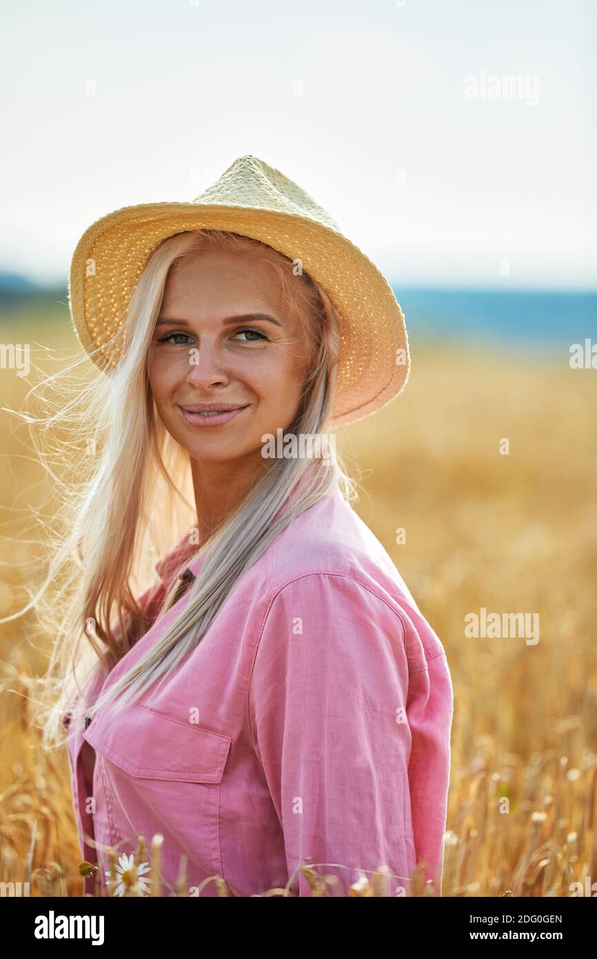 Woman with long blond hair and a straw hat in a wheat field Stock Photo ...
