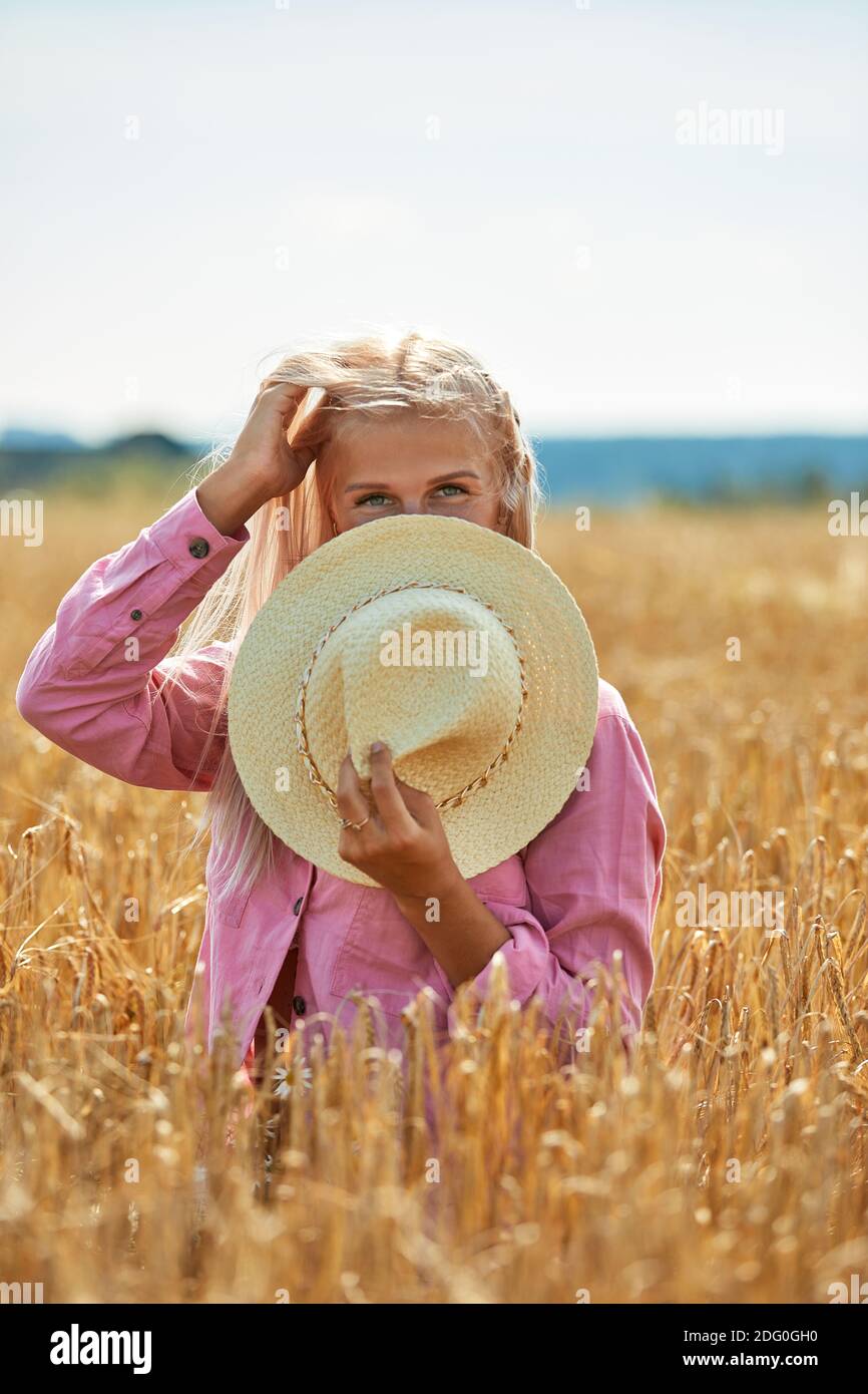 Woman with long blond hair and a straw hat in a wheat field Stock Photo ...