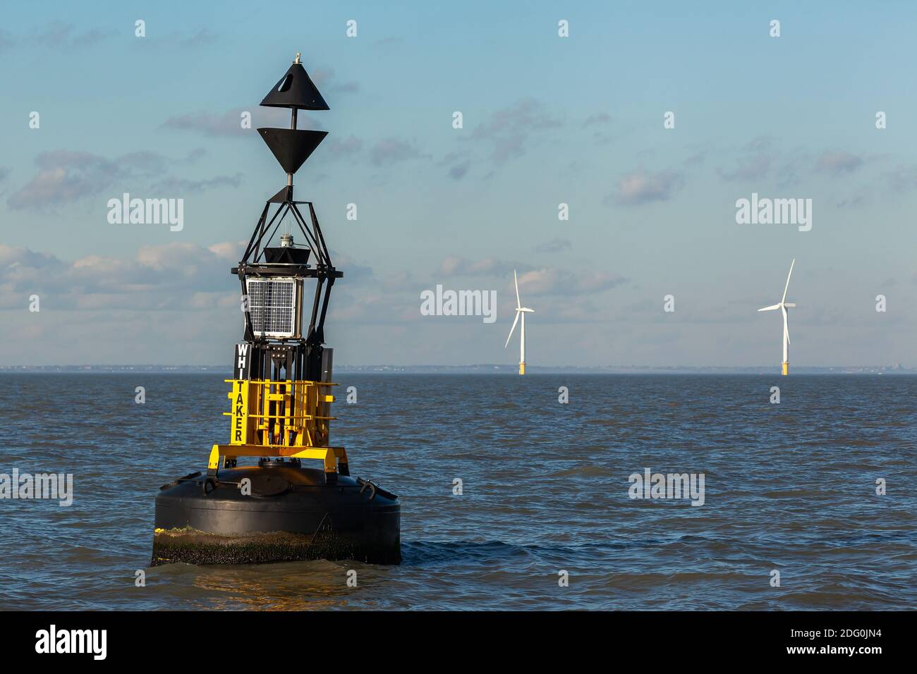 East cardinal buoy with a wind farm visible in the background on a calm
