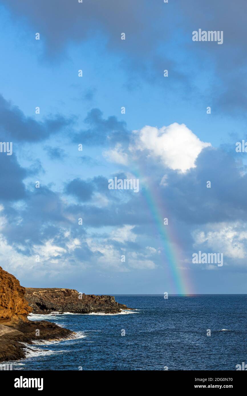 Rainbow over the sea offshore from yellow mountain, Montaña Amarilla, Costa Silencio, Tenerife, Canary Islands, Spain Stock Photo