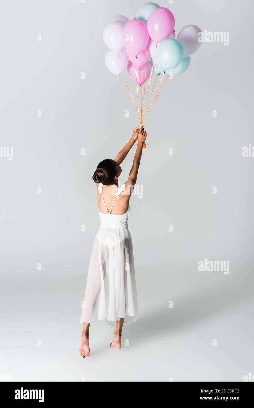 back view of barefoot graceful african american ballerina in dress ...