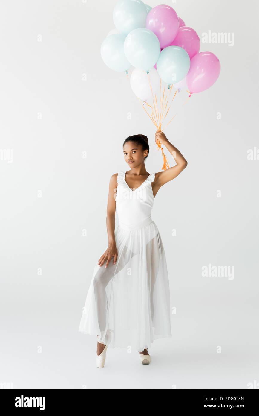 graceful african american ballerina with balloons isolated on white ...