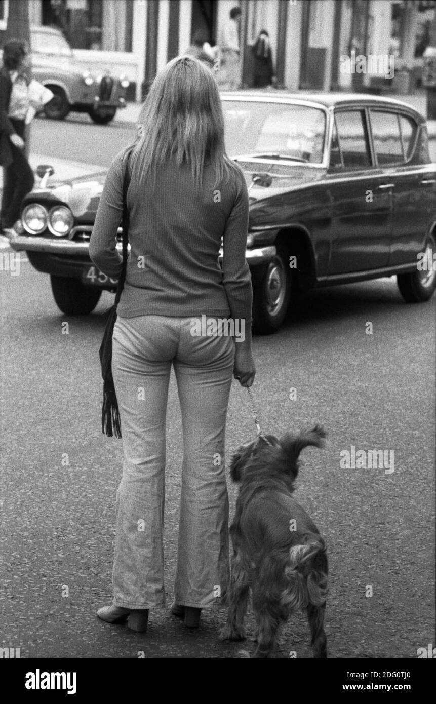 A young woman with a dog crosses the street. London, England, 1971 Stock Photo