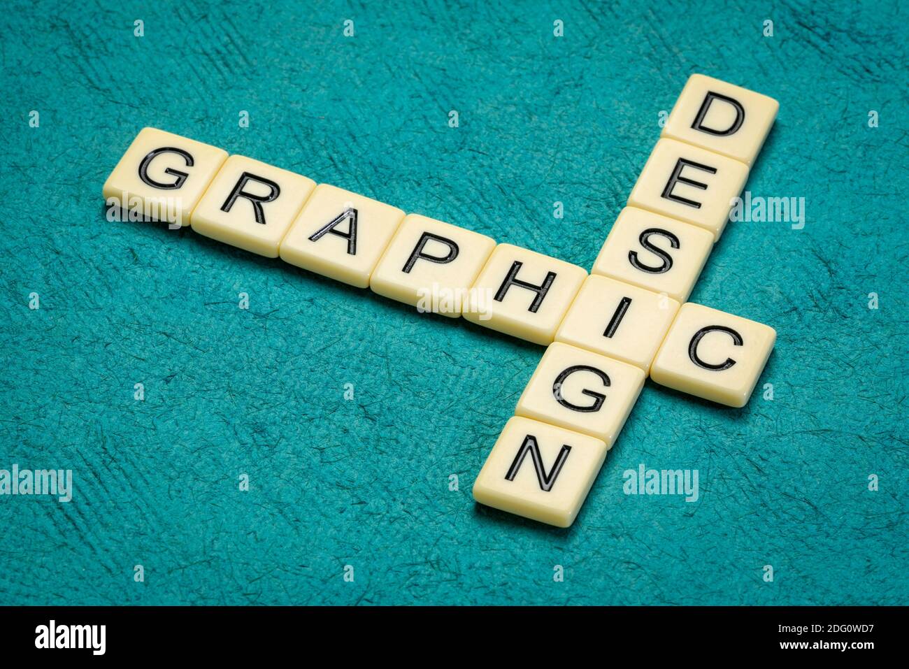 graphic design crossword in ivory letter tiles against textured handmade paper, vidual content and communication concept Stock Photo