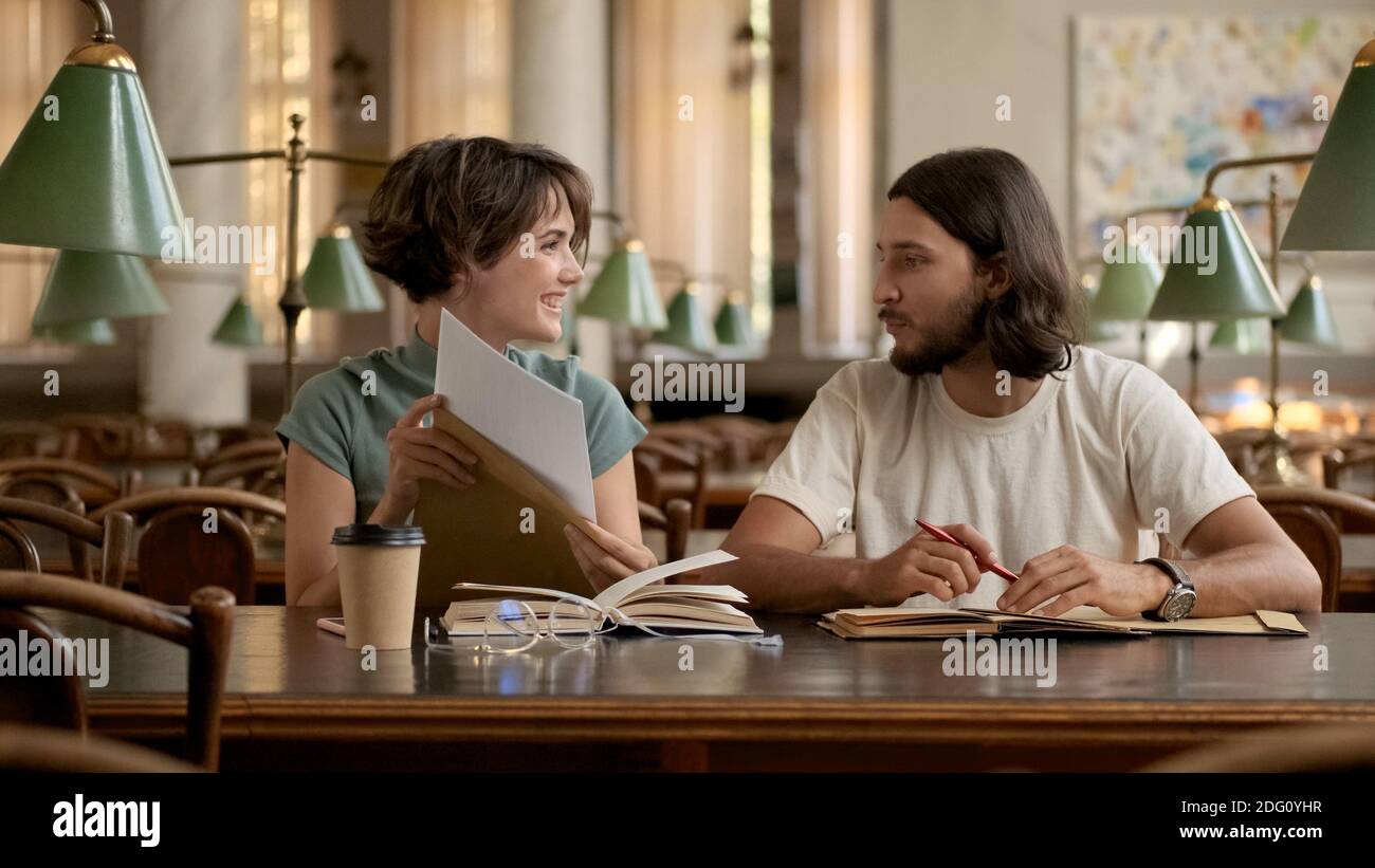 Attractive smiling college students happily opening exam results. Young students studying together in university Stock Photo