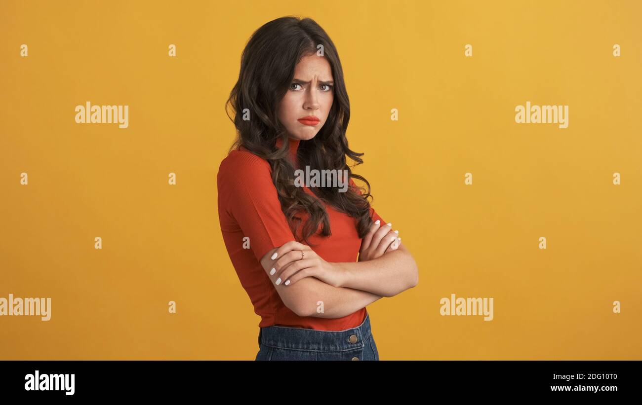 Red Offend Offended girl in red top with hands crossed sadly looking in camera ...