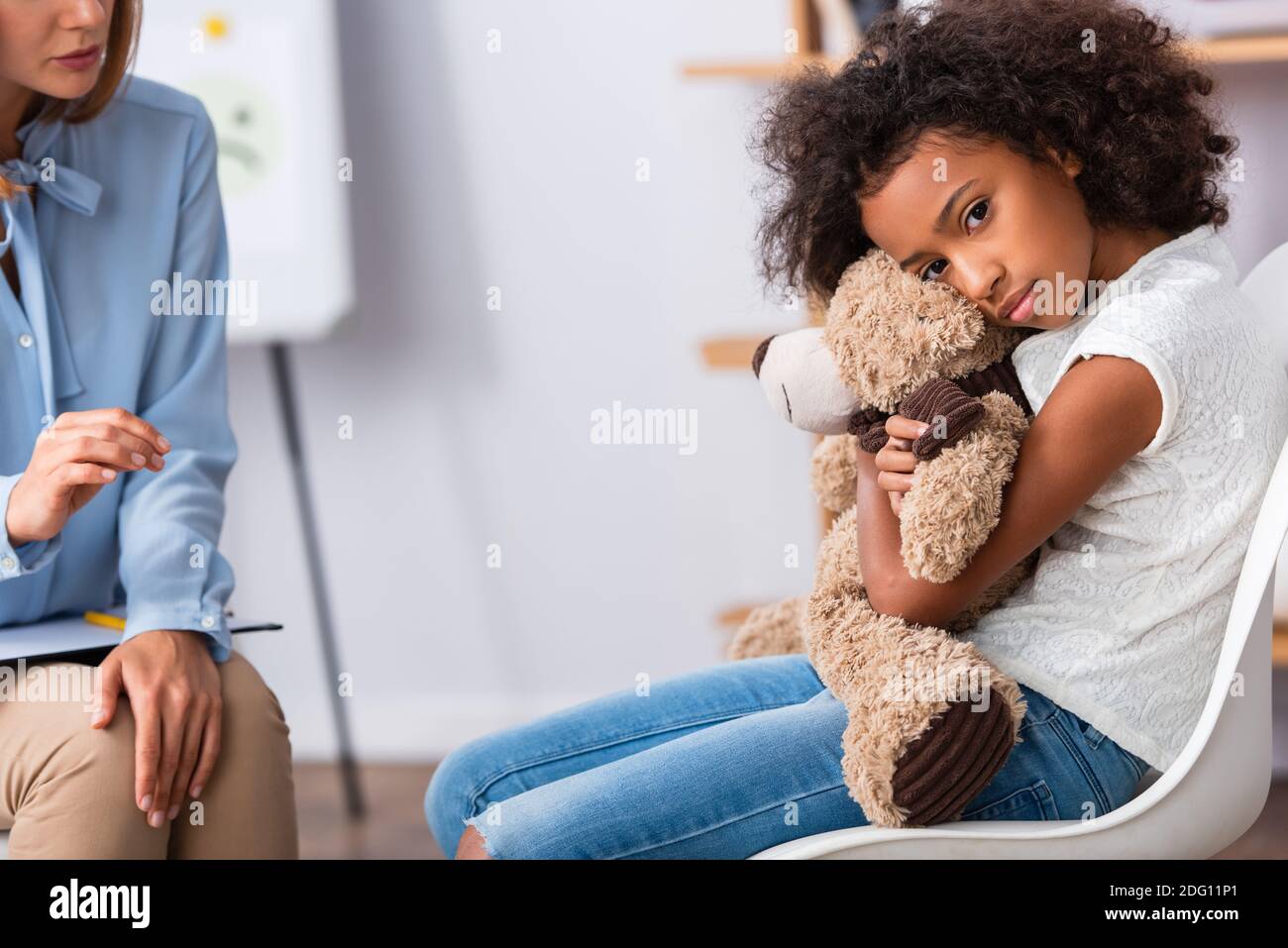 Depressed african american girl with autism looking at camera and