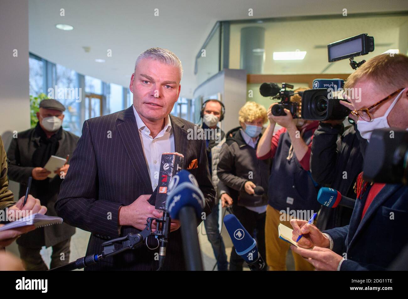 07 December 2020, Saxony-Anhalt, Magdeburg: Holger Stahlknecht leaves the hall after the CDU faction meeting and gives a statement to waiting media representatives. For Saxony-Anhalt's black-red-green coalition, a week begins with decisive decisions. How to proceed in the deadlocked dispute over the vote on the state treaty, which provides for an increase in broadcasting fees, was the topic of the faction meeting. Meanwhile, it is still open who will succeed Stahlknecht as Minister of the Interior and party leader of the CDU in Saxony-Anhalt. The state premier had dismissed him on Friday in re Stock Photo