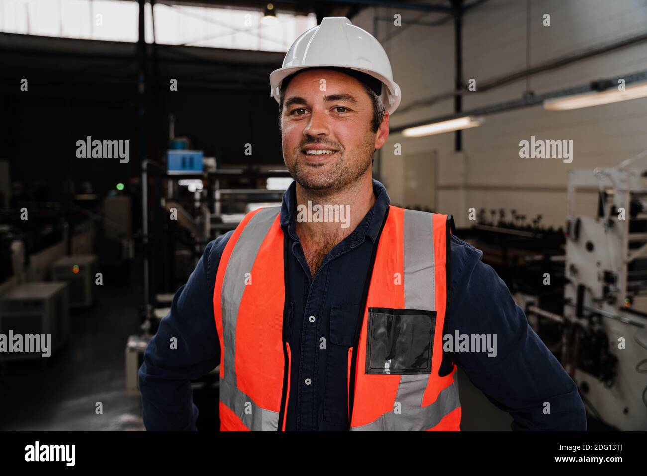 Caucasian male engineer smiling wearing hardhat in warehouse Stock ...