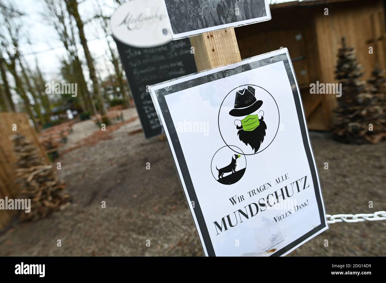 A sign reading 'We all wear mouth protection' is seen at the entrance to a closed beer garden as the spread of the coronavirus (COVID-19) disease continues in Munich, Germany, December 7, 2020. REUTERS/Andreas Gebert Stock Photo