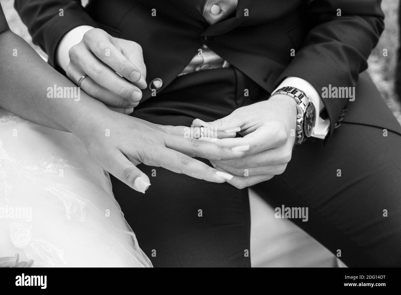 details of the hands while exchanging wedding rings, wedding reportage, black-and-white photography Stock Photo