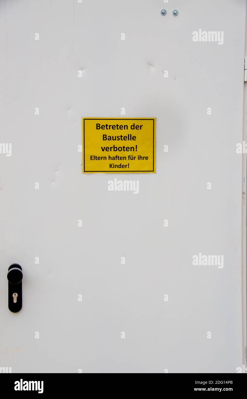 Door with inscription Entering the construction site prohibited. Parents are liable for their children in German Stock Photo