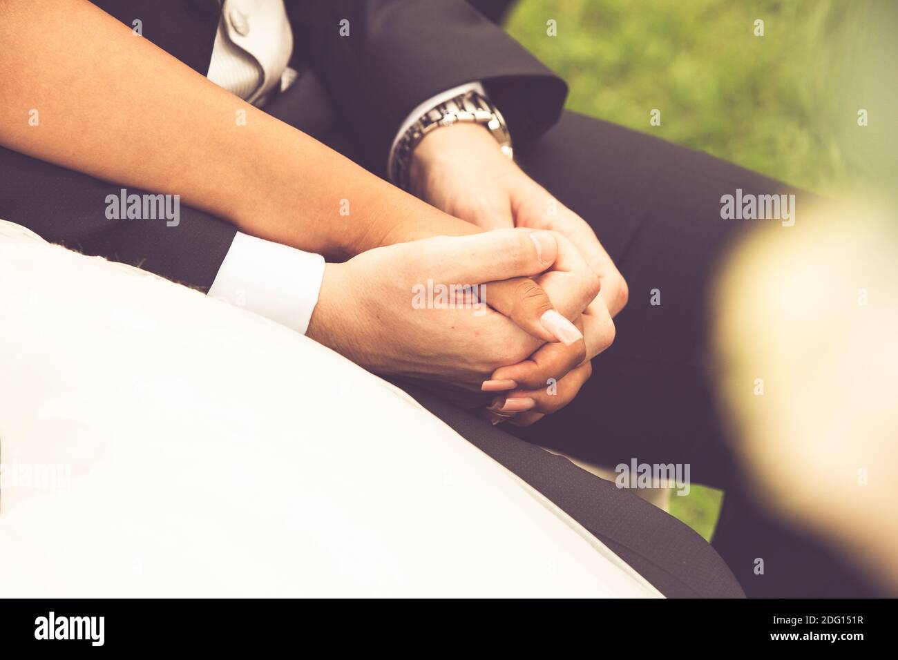 hands of two newlyweds holding hands during the ceremony Stock Photo