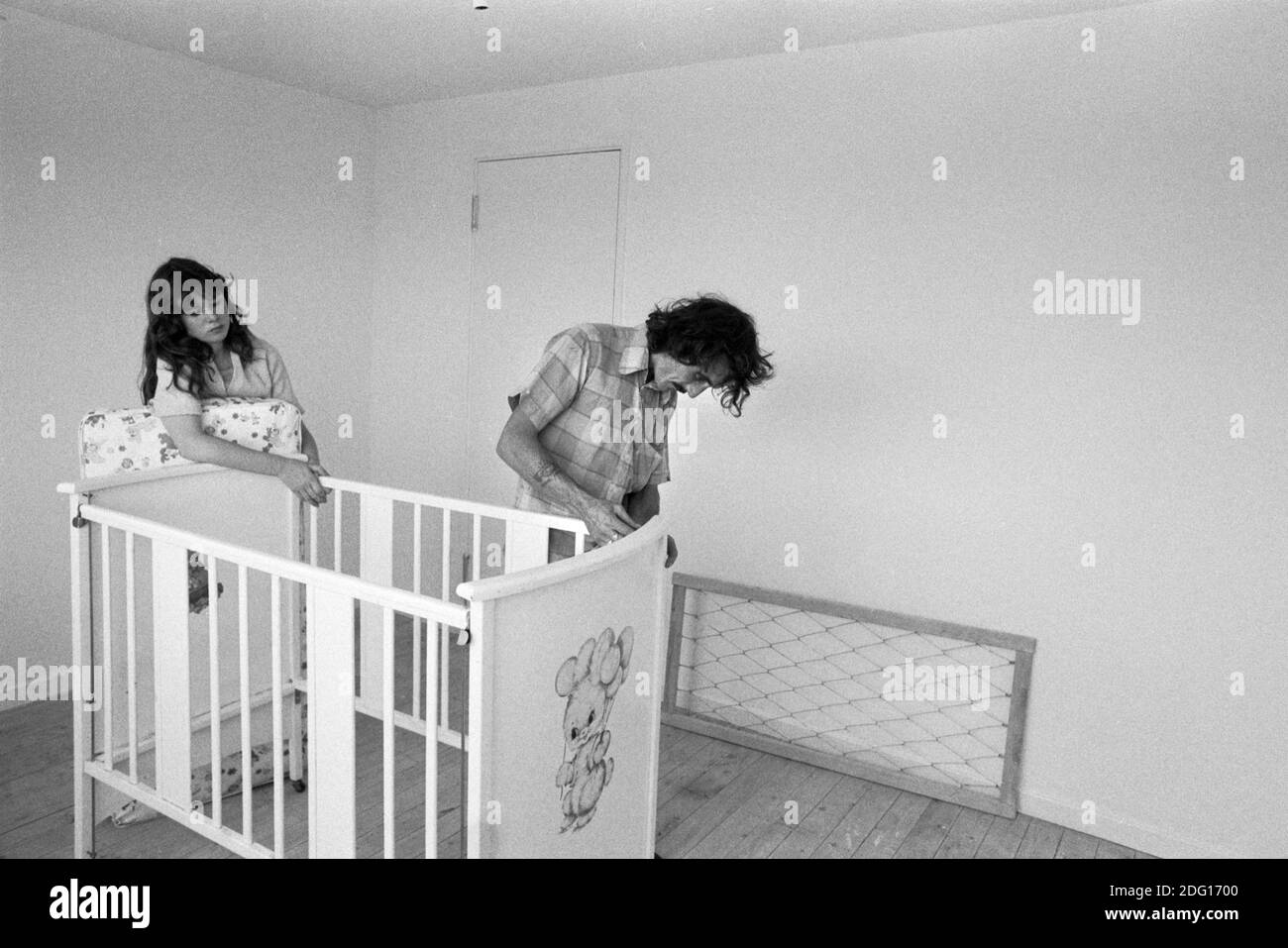 Putting up the babys cot, father eldest daughter they have just moved into a new family home. The removal men have left and they are getting everything ready for their first night in the new family home. New estate UK 1977 1970s Milton Keynes, Buckinghamshire HOMER SYKES. Stock Photo