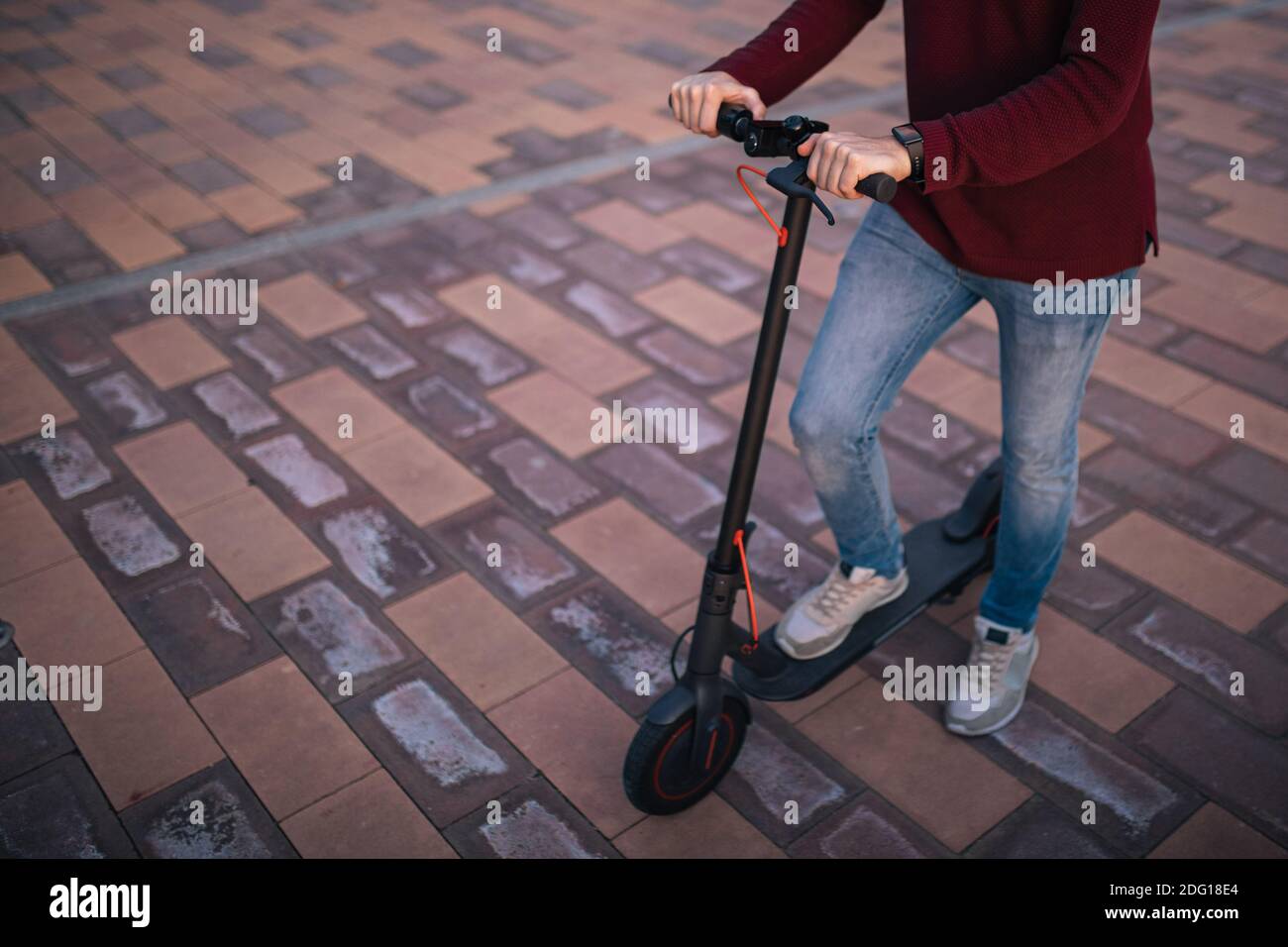 e-scooter on the street, with a young man driving it Concept technology. Stock Photo