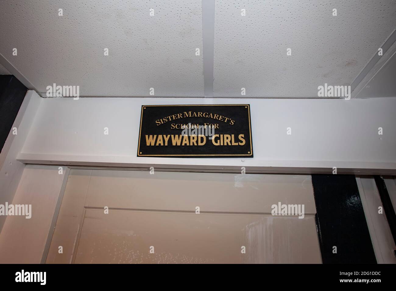Humorous sign 'Sister Margaret's school for Wayward Girls' sign above a sliding door Stock Photo
