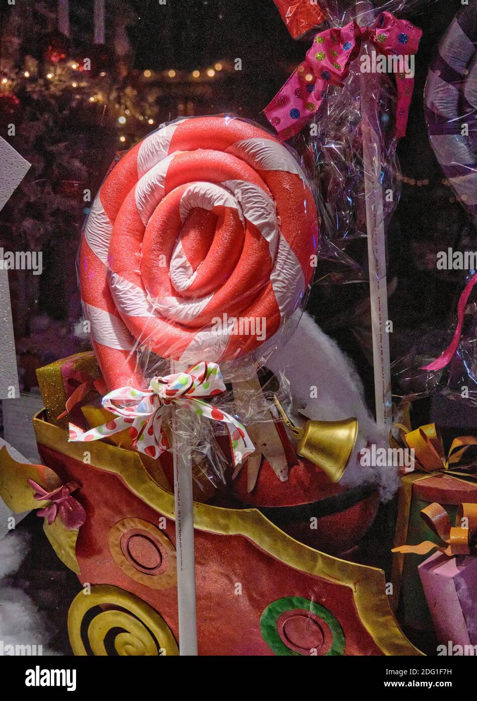 A large red and white lollipop and model sleigh decorate a Lewes, Delaware store window during the Christmas holiday season. Stock Photo