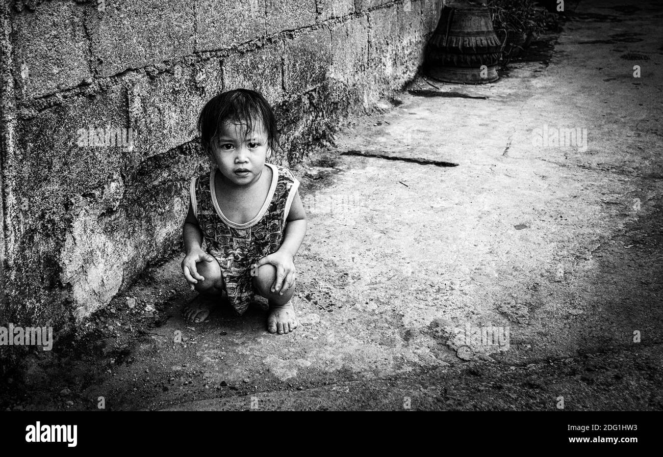 Little poor child crouching Stock Photo