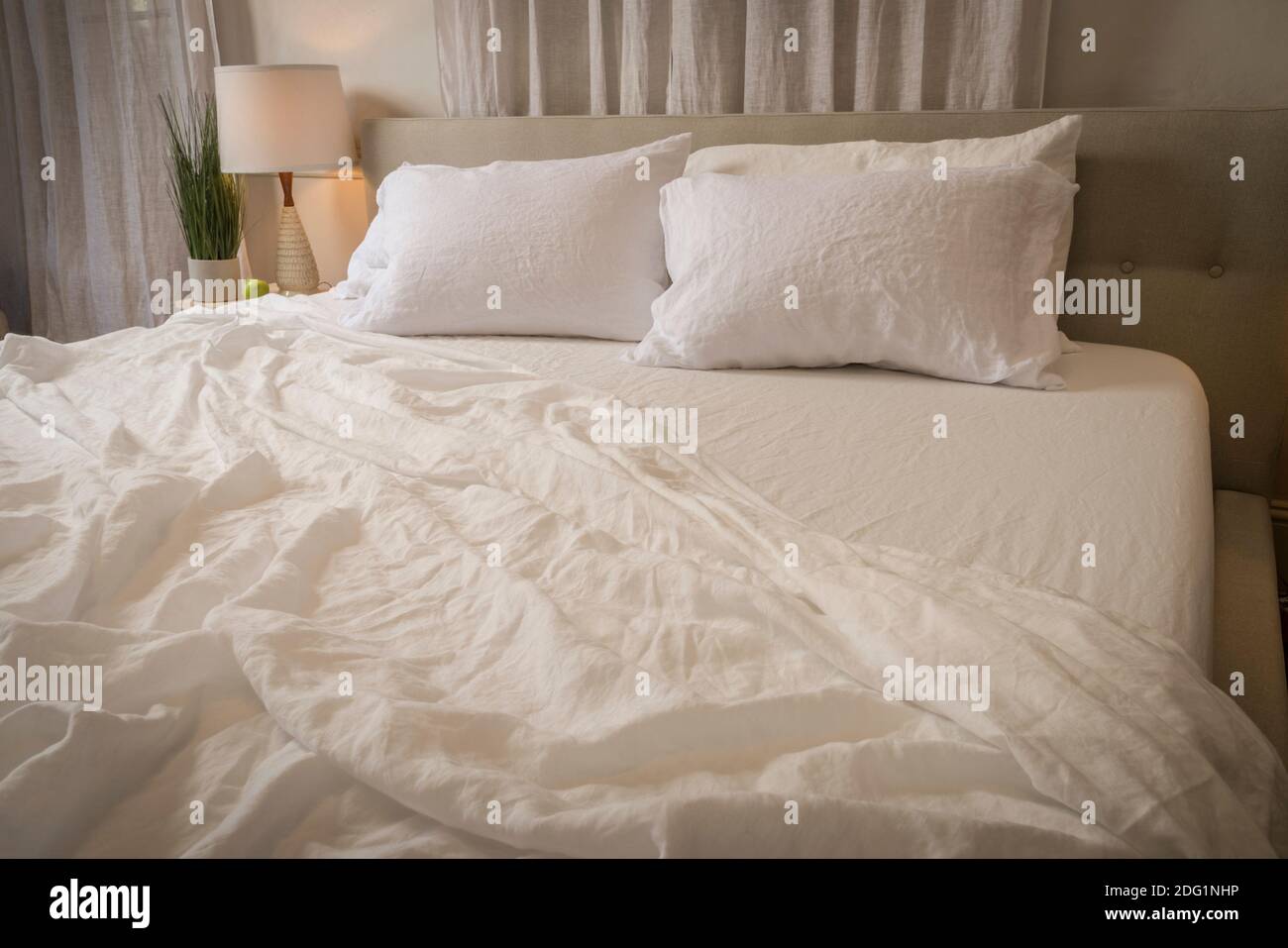Wrinkled bed sheets in messy bedroom, USA Stock Photo