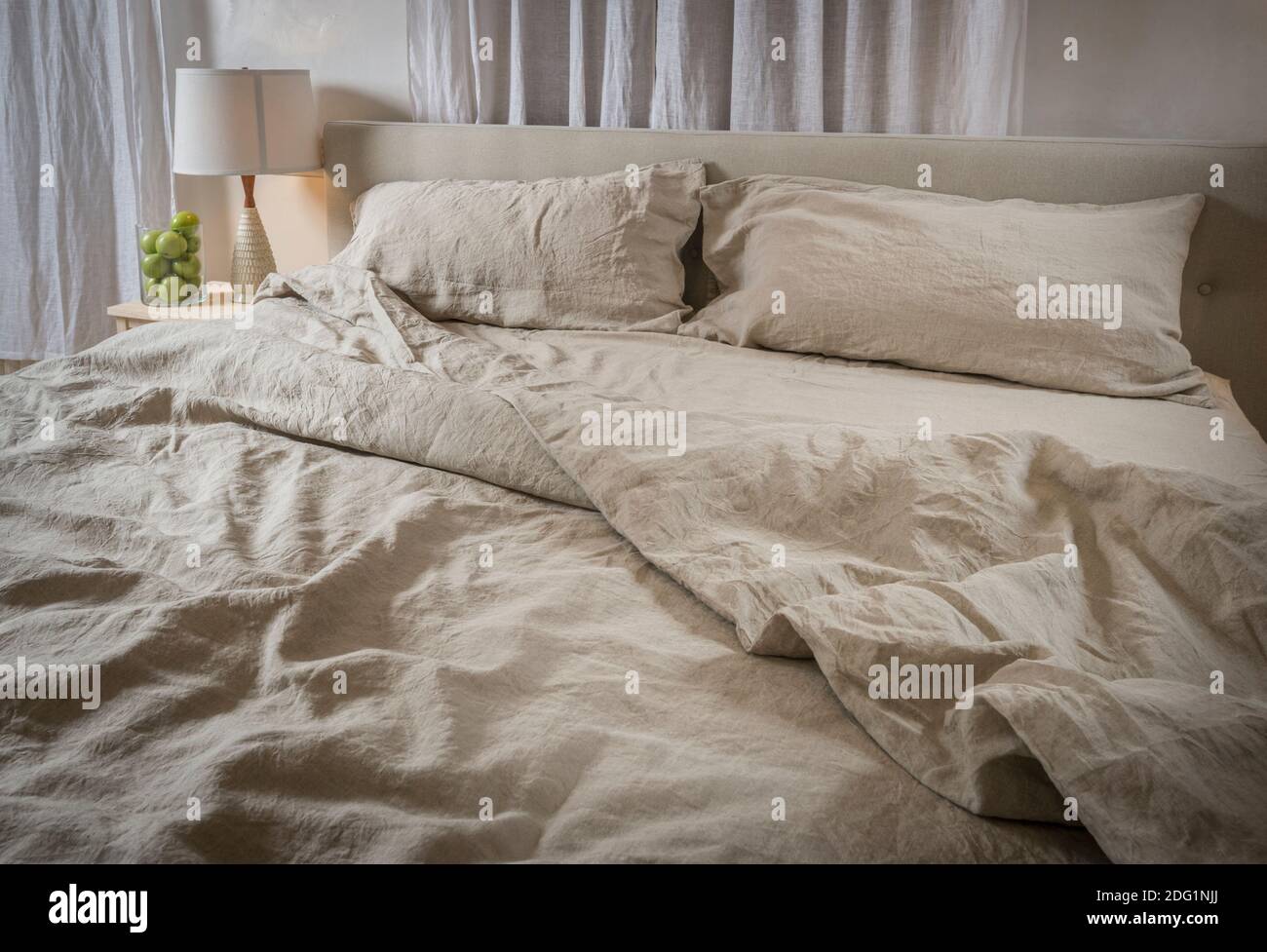 Wrinkled bed sheets in messy bedroom, USA Stock Photo