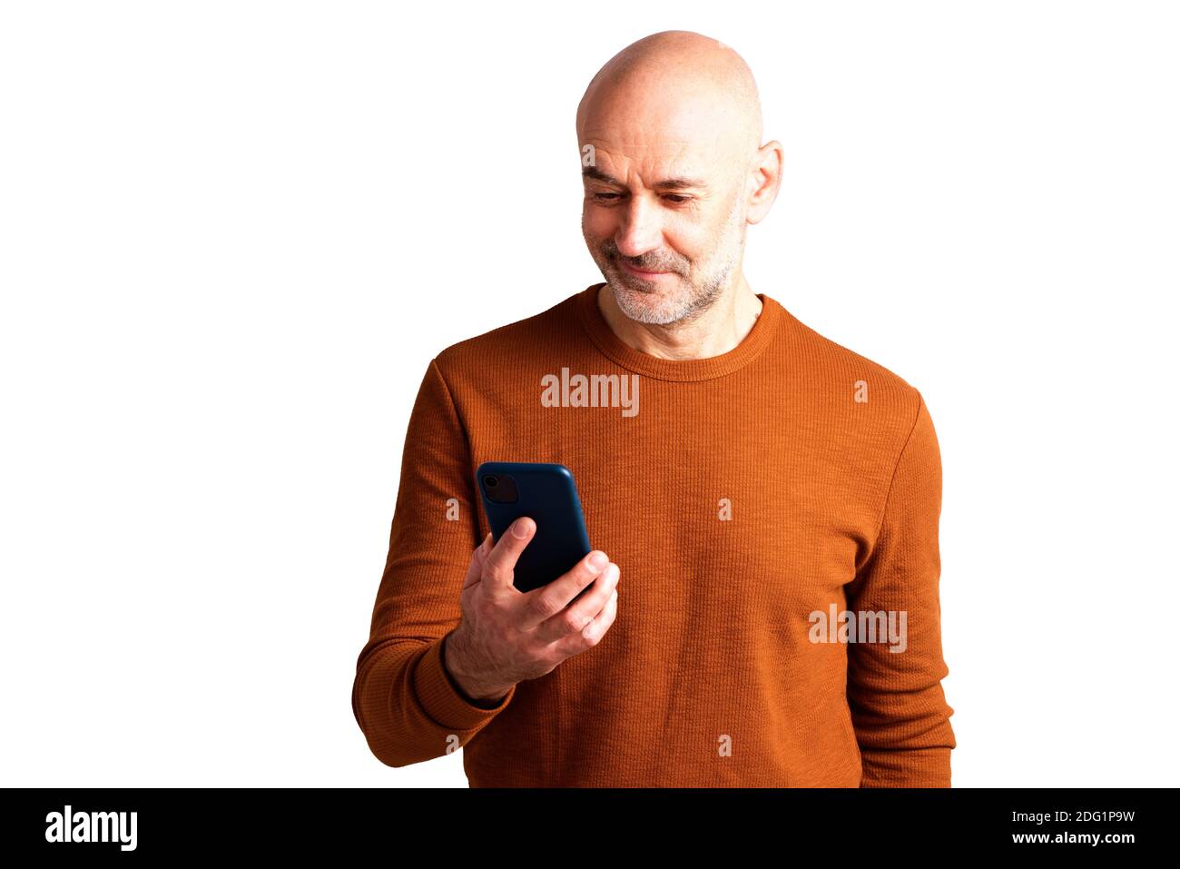 Portrait shot of smiling senior man text messaging while standing at isolated white background. Stock Photo