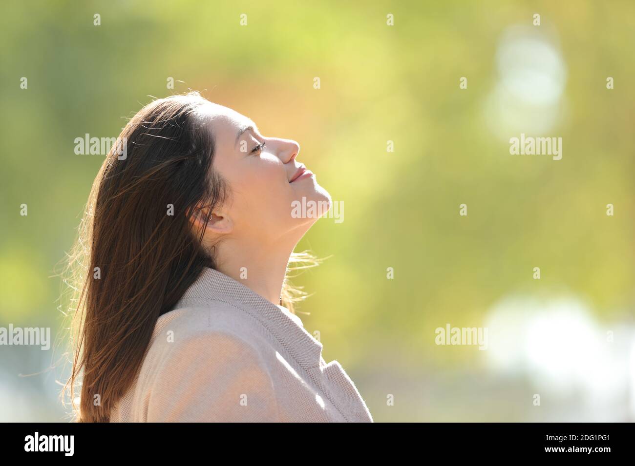 Side view portrait of a relaxed entrepreneur breathing fresh air in a park Stock Photo