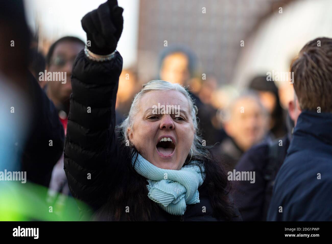 Anti-lockdown protest in Stratford, London, 5 December 2020. A female protester raises her arm and shouts. Stock Photo